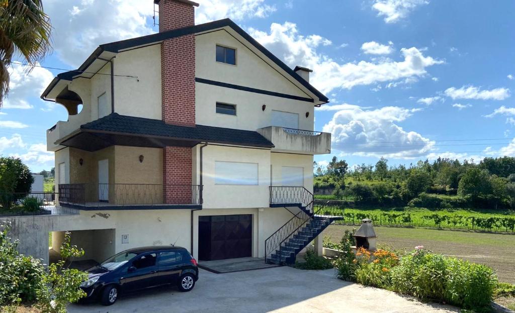 a house with a car parked in front of it at Casa do Tojal in Fiscal