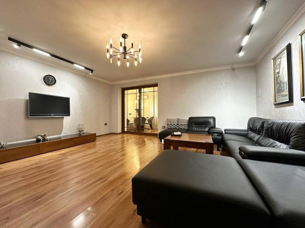 a living room with a couch and a tv at Cozy Retreat in Green Dúbravka in Bratislava