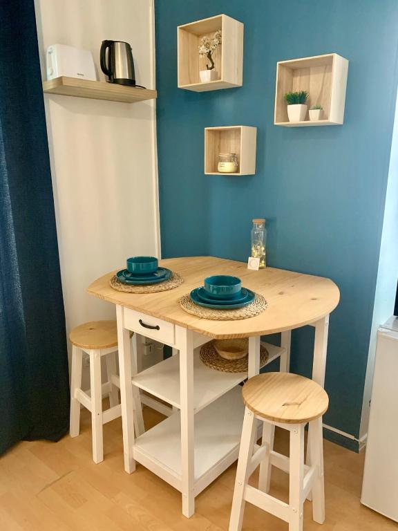 une table et des tabourets dans une pièce avec une table et des chaises dans l'établissement Le Petit Nid, à Longwy