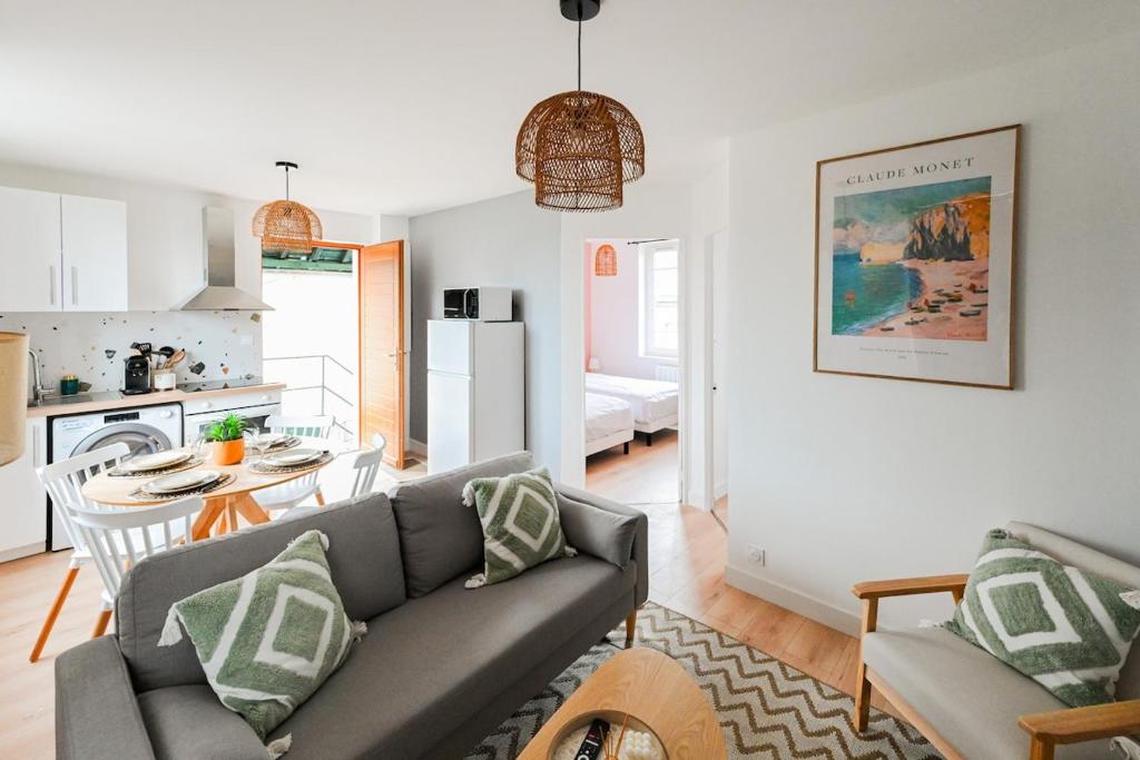 a living room with a couch and a table and a kitchen at La Pinta - Fécamp in Fécamp
