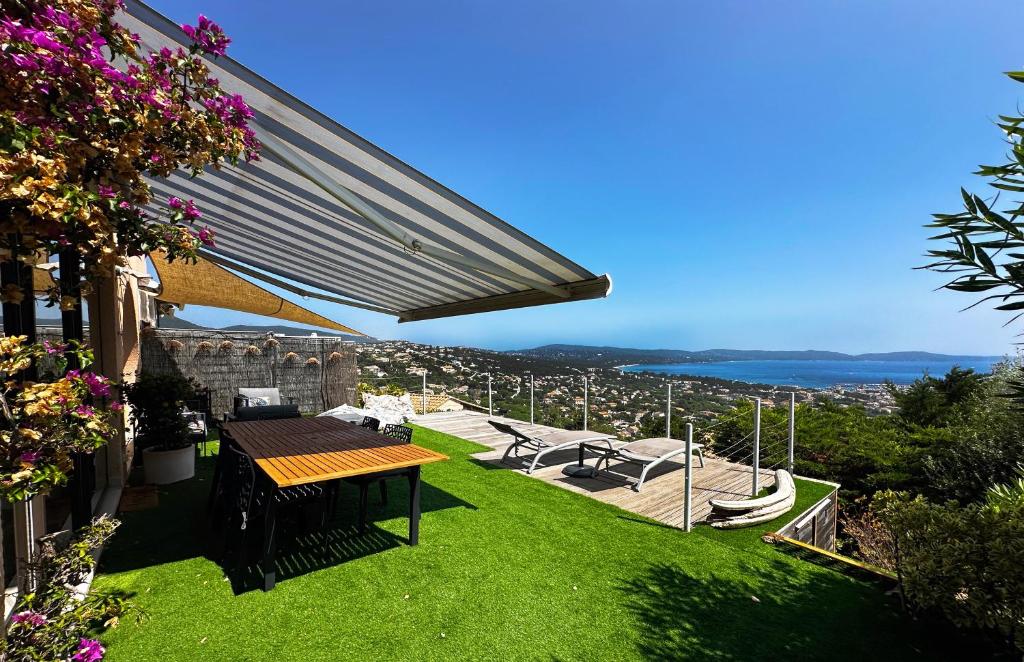d'une terrasse avec une table et une vue sur la ville. dans l'établissement La Terrasse de Marie - superbe vue, terrasse, piscine, à Cavalaire-sur-Mer