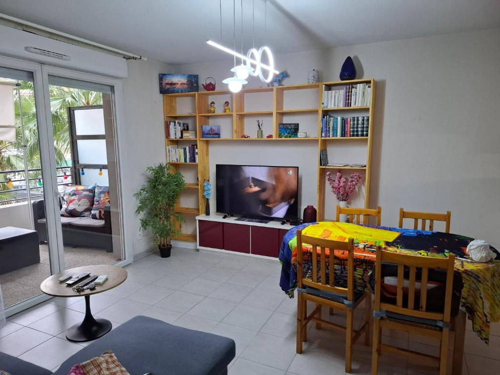 un salon avec une télévision et une salle à manger dans l'établissement Appartement Beau Sejour, à Marseille