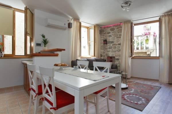 a kitchen and living room with a white table and chairs at Old Town Apartment Mila in Split