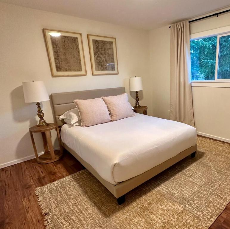 a bedroom with a bed with two lamps and a window at Pool, Sauna, Spa, & Fire-pit in Ukiah