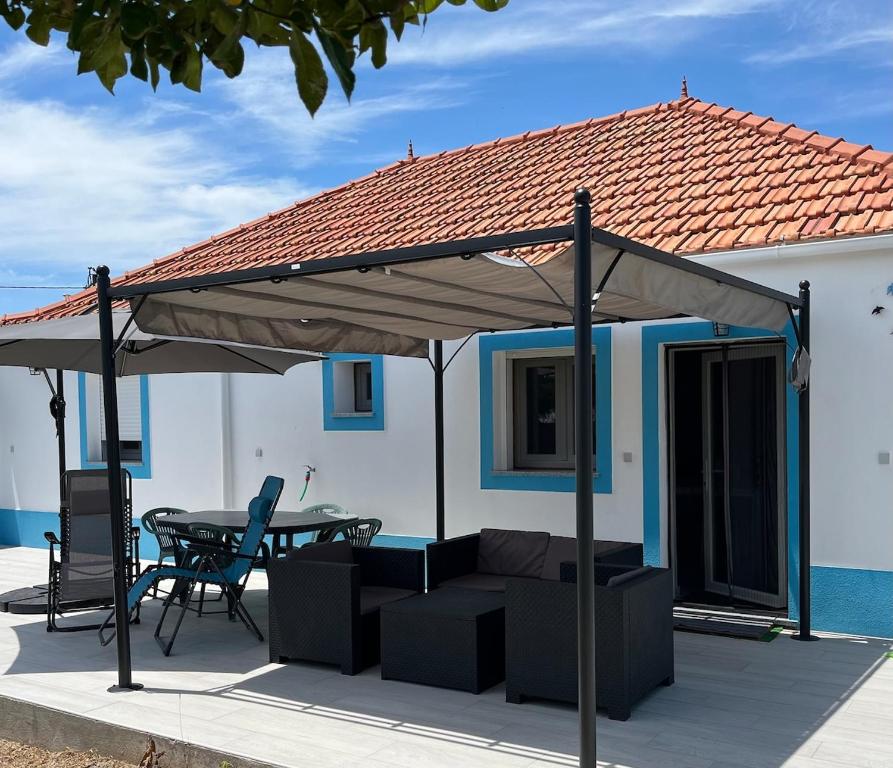 un patio con baldacchino, tavolo e sedie. di Quinta das Andorinhas Alentejo countryside and beach ad Alcácer do Sal