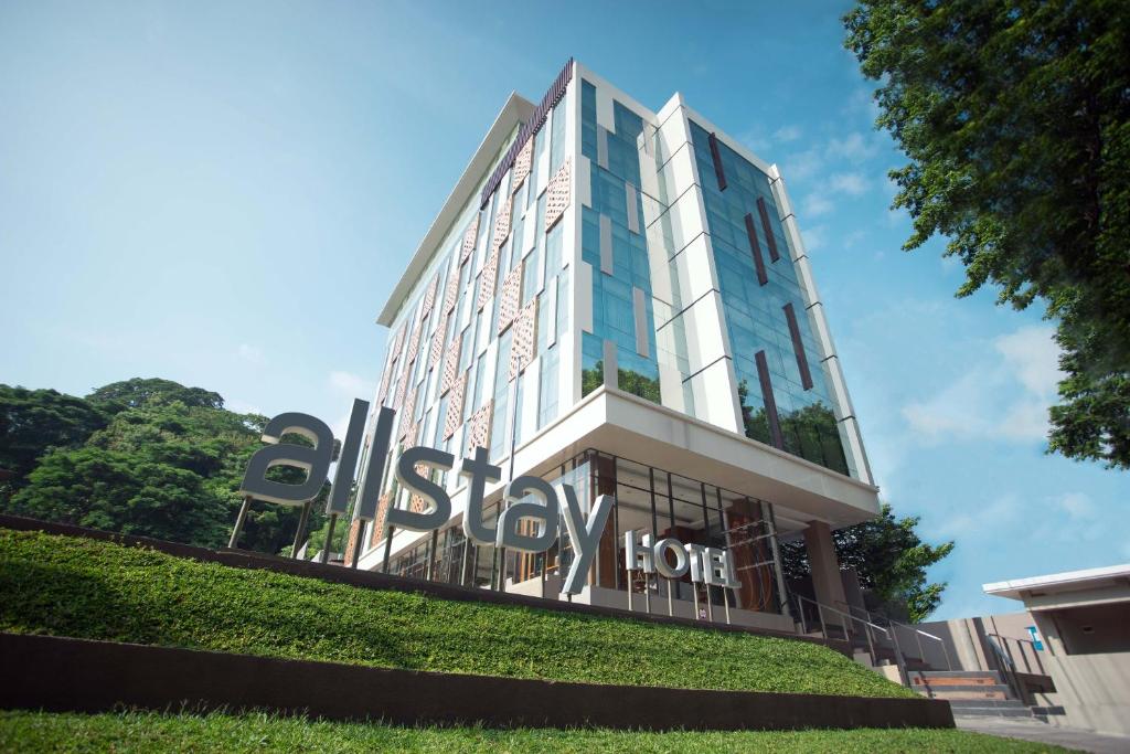 un bâtiment avec un panneau sur son côté dans l'établissement Allstay Hotel Semarang Simpang Lima, à Semarang