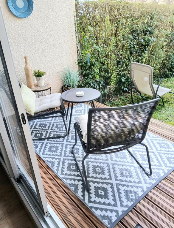- une petite terrasse avec 2 chaises et une table dans l'établissement Cosy studio le Garden ensoleillé, à Cabourg
