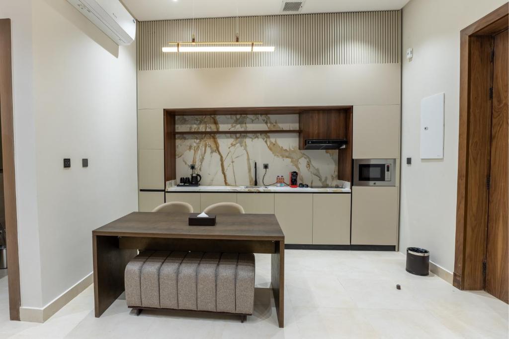a kitchen with a wooden table and chairs at فندق ليورا Liora Hotel in Riyadh