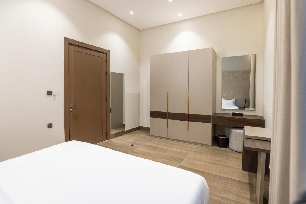 a bedroom with a bed and a desk and a mirror at فندق ليورا Liora Hotel in Riyadh