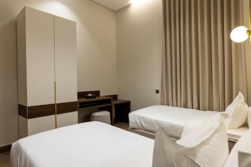 a hotel room with two beds and a desk at فندق ليورا Liora Hotel in Riyadh