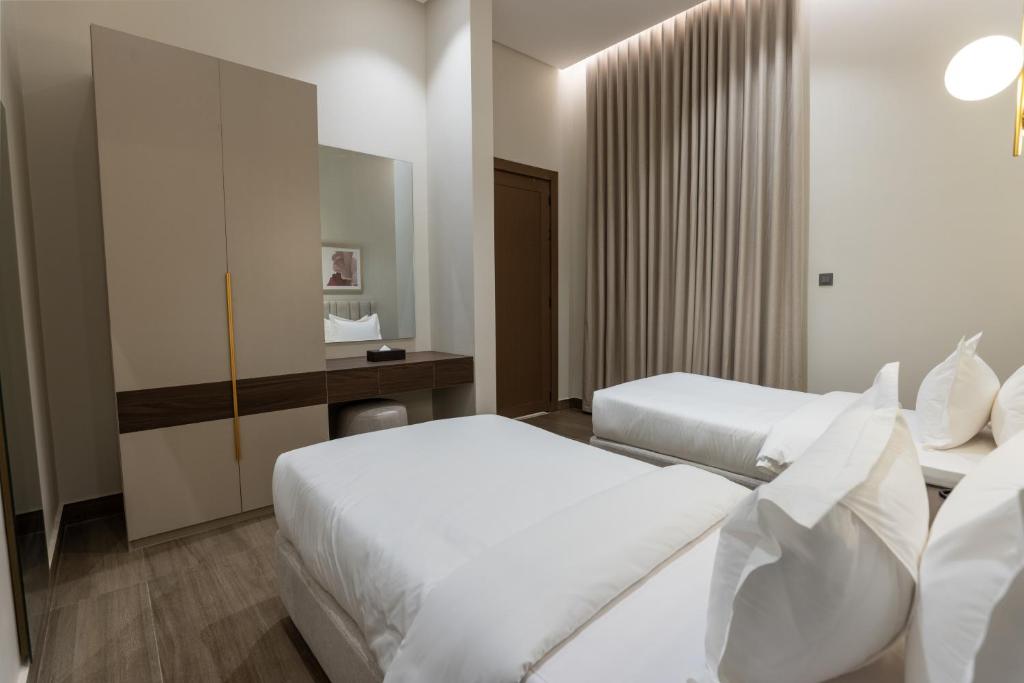 a hotel room with two beds and a mirror at فندق ليورا Liora Hotel in Riyadh