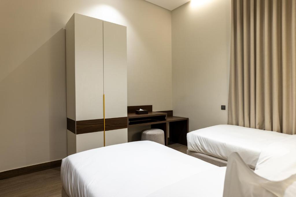 a hotel room with two beds and a cabinet at فندق ليورا Liora Hotel in Riyadh