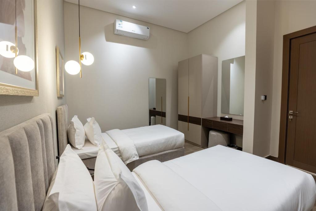 a hotel room with two beds and a mirror at فندق ليورا Liora Hotel in Riyadh