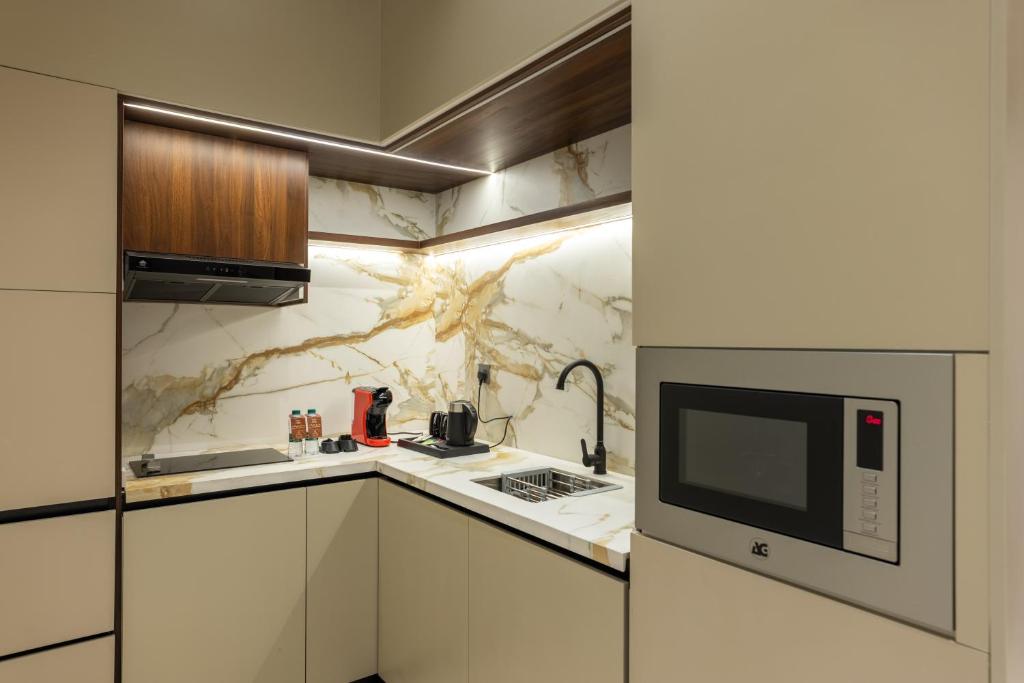 a kitchen with a sink and a microwave at فندق ليورا Liora Hotel in Riyadh