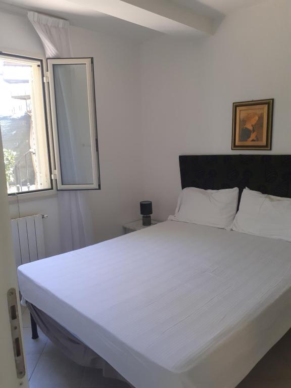 a white bed in a room with a window at Casa al mare in Sperlonga