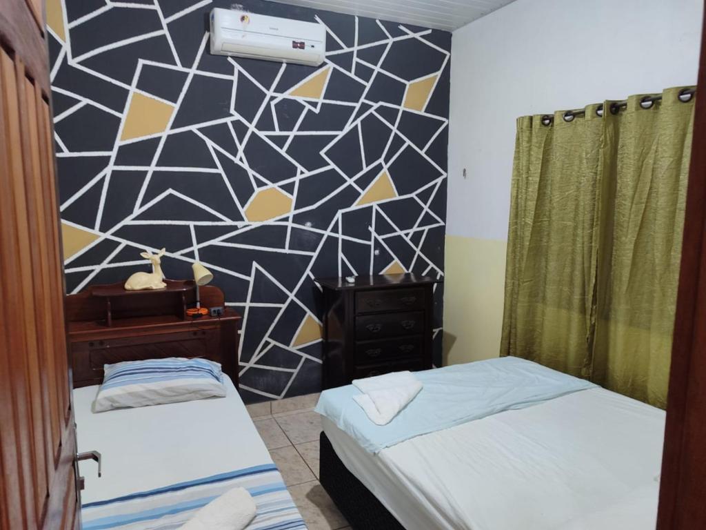 a room with two beds and a geometric wall at Quartos em Alter do Chão in Santarém