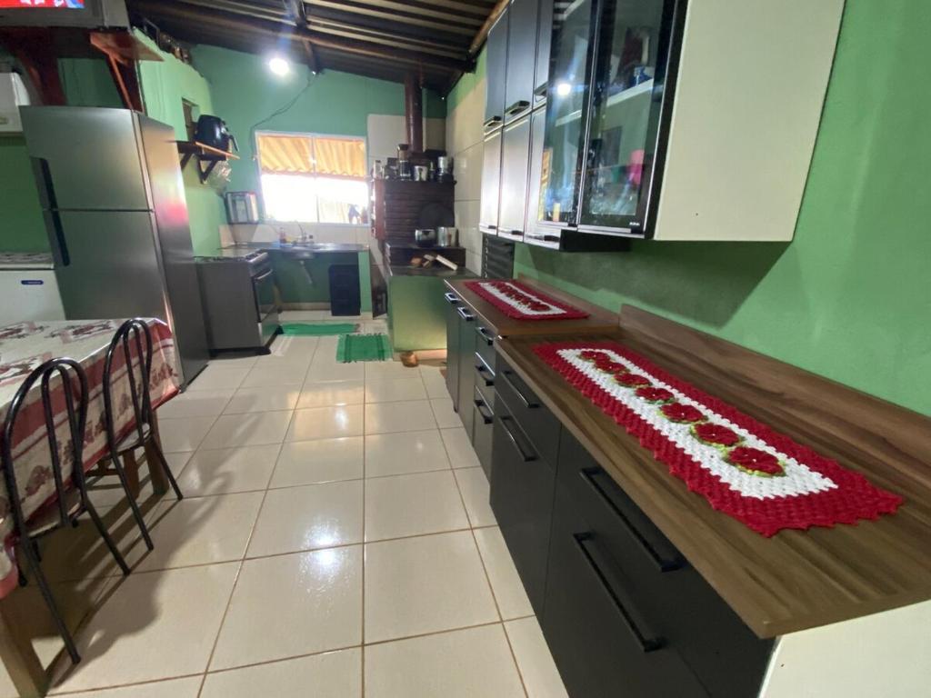 a kitchen with a counter with a red and white ingrediants at Aconchego ao pé da serra in São Roque de Minas