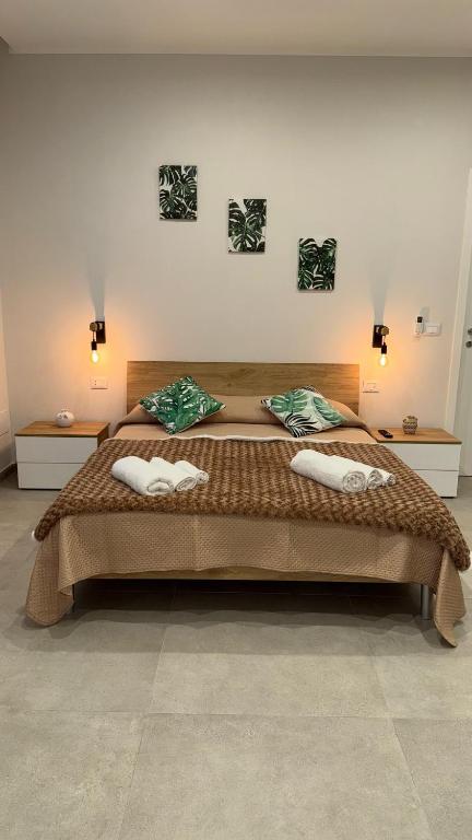 a bedroom with a large bed with two towels on it at Le Palme - Holiday Home in Brindisi