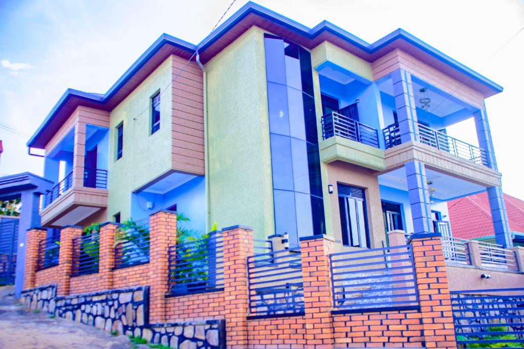 une maison colorée avec une clôture en briques devant elle dans l'établissement Number Seven apartment, à Kigali