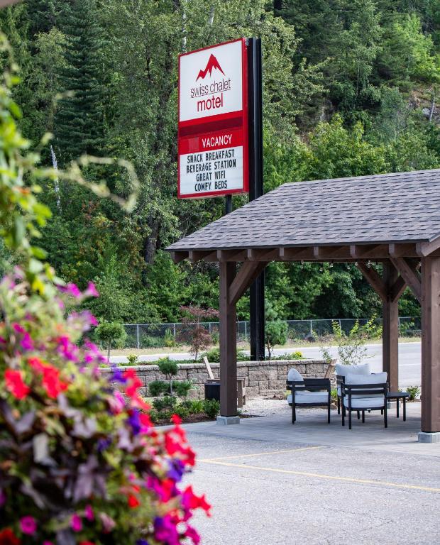a gas station with benches and a sign for aadobeadobeadobeadobeadobeadobe at Swiss Chalet Motel in Revelstoke