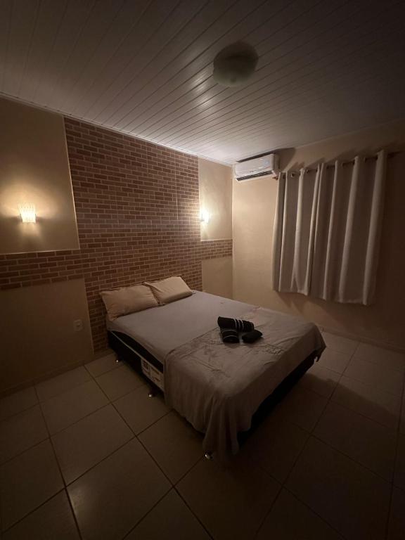 una camera da letto con un letto con una borsa nera sopra di Suítes privativas a Cachoeiras de Macacu