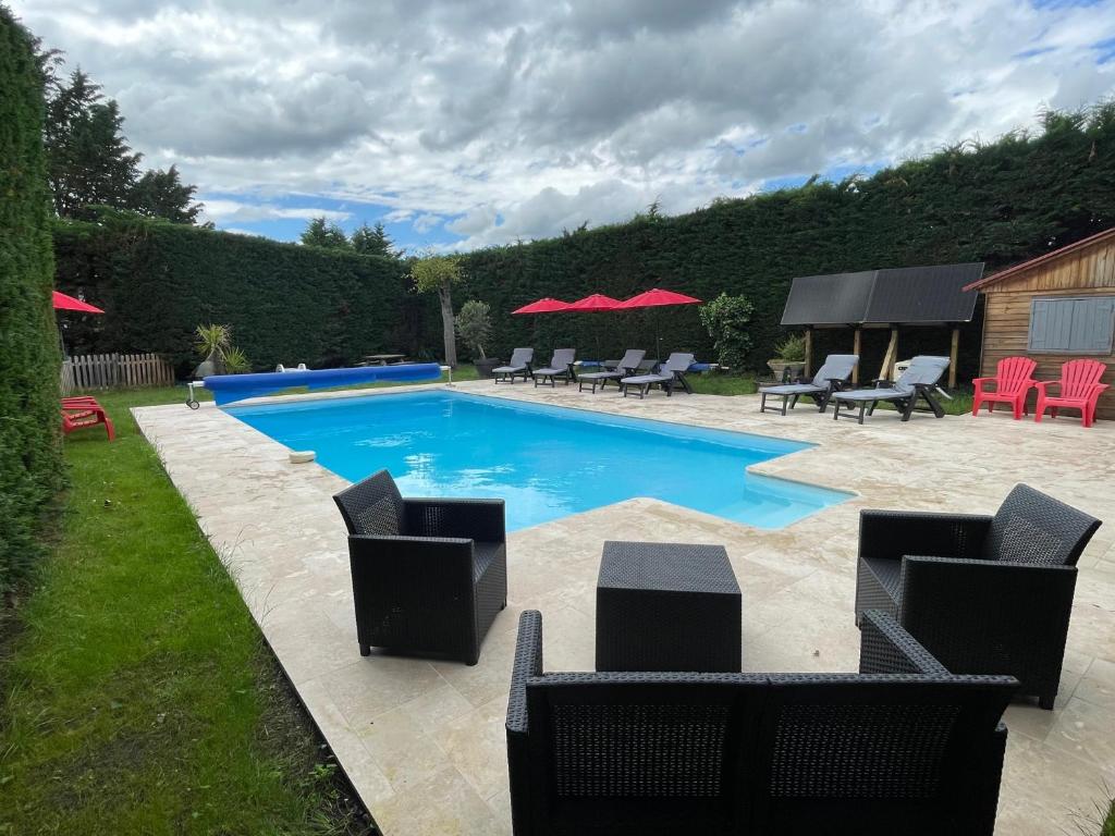 una piscina con sedie e tavoli in un cortile di Domaine entier Le Clos des Trois Provinces 20 personnes Zoo Beauval a Noyers-sur-Cher