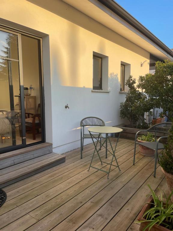 a patio with a table and chairs on a deck at Charmante chambre chez l habitant in La Teste-de-Buch