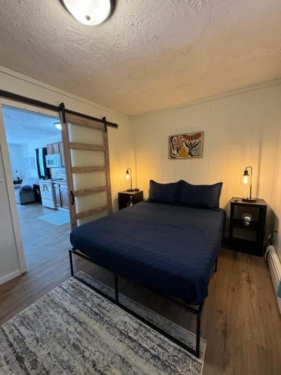 a bedroom with a bed with a blue comforter at Elevated Ski Chalet at Powderhorn Mountain in Bessemer