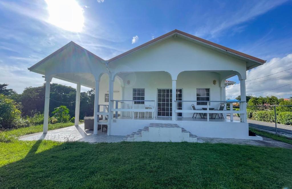 a small white house with a grass yard at Grace's Place in Sapphire