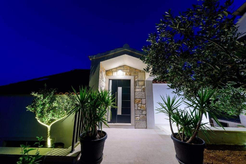a house with two potted plants in front of a door at Apartments with WiFi Bol, Brac - 23862 in Bol