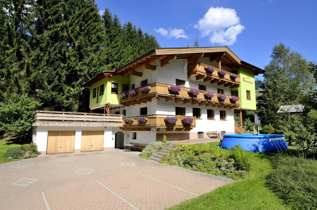 a house with a balcony and a parking lot at Haus Brandner in Viehhofen