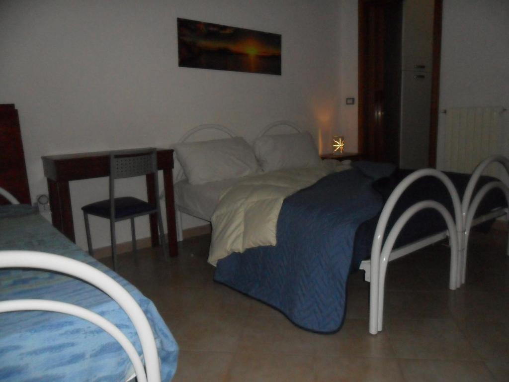 una camera con letto, tavolo e sedie di La Stanza Alternativa a Sannicola