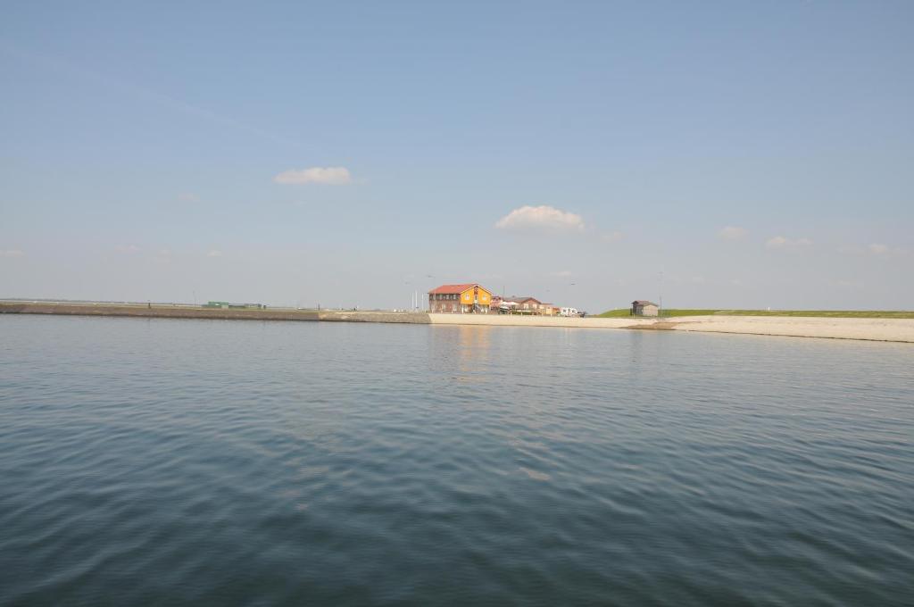 een grote hoeveelheid water met een huis op de achtergrond bij Residentie Oosterschelde in Sint Philipsland