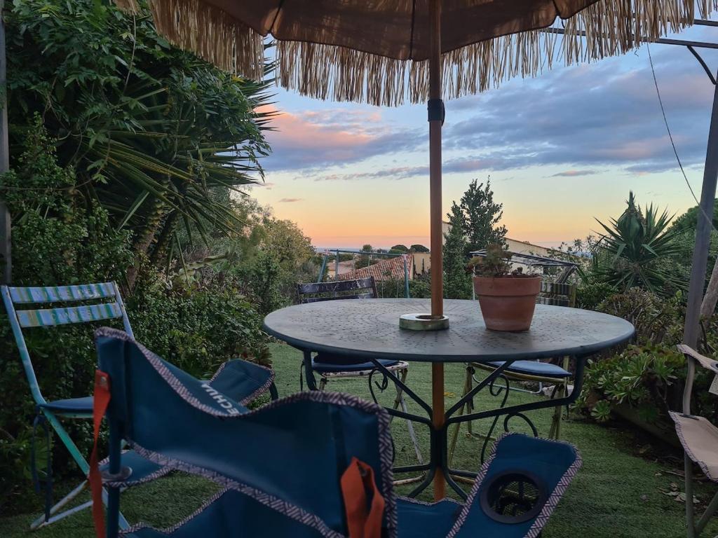 - une table et des chaises sur une terrasse avec un parasol dans l'établissement flat with sea view, à Antibes