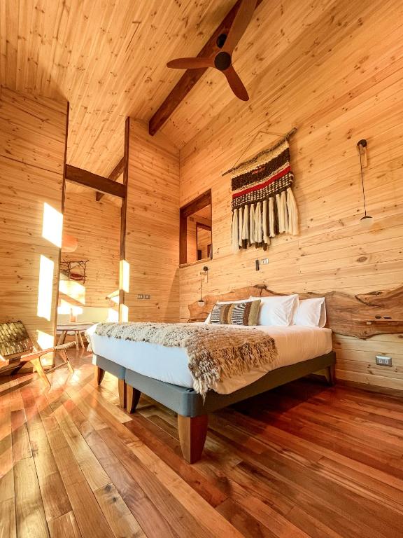 a bedroom with a bed in a wooden room at NI-NEWEN Hotel & Lodge in Pucón