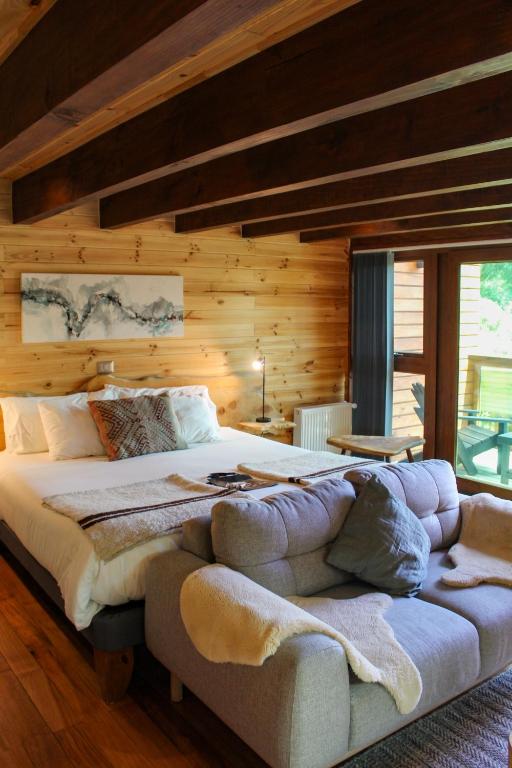 a bedroom with a large bed in a wooden wall at NI-NEWEN Hotel & Lodge in Pucón