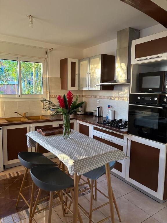 a kitchen with a table with a vase of flowers on it at Villa Mont Horizon in Saint-Pierre
