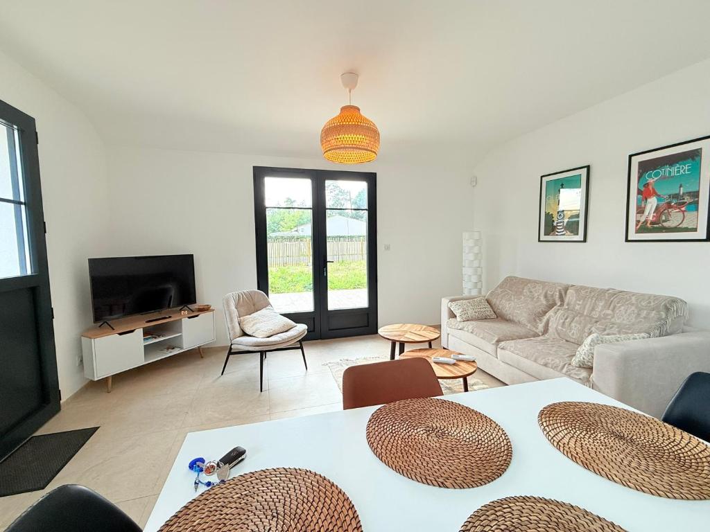 un salon avec un canapé et une télévision dans l'établissement Maison neuve à 300m de la plage pour 4 pers, St-Pierre-d'Oléron - FR-1-778-42, à Saint-Pierre-dʼOléron