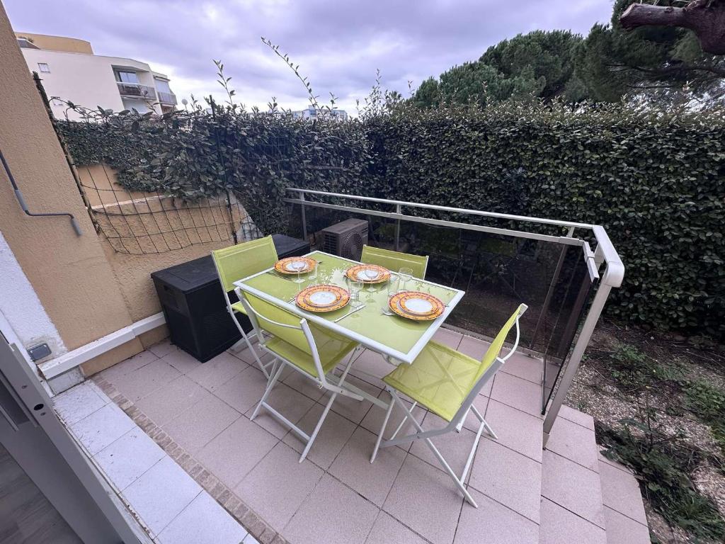 une table et des chaises assises sur un balcon avec une table et des chaises dans l'établissement Appartement 2 Pièces Climatisé avec Garage - Grau-du-Roi - FR-1-731-131, au Grau-du-Roi