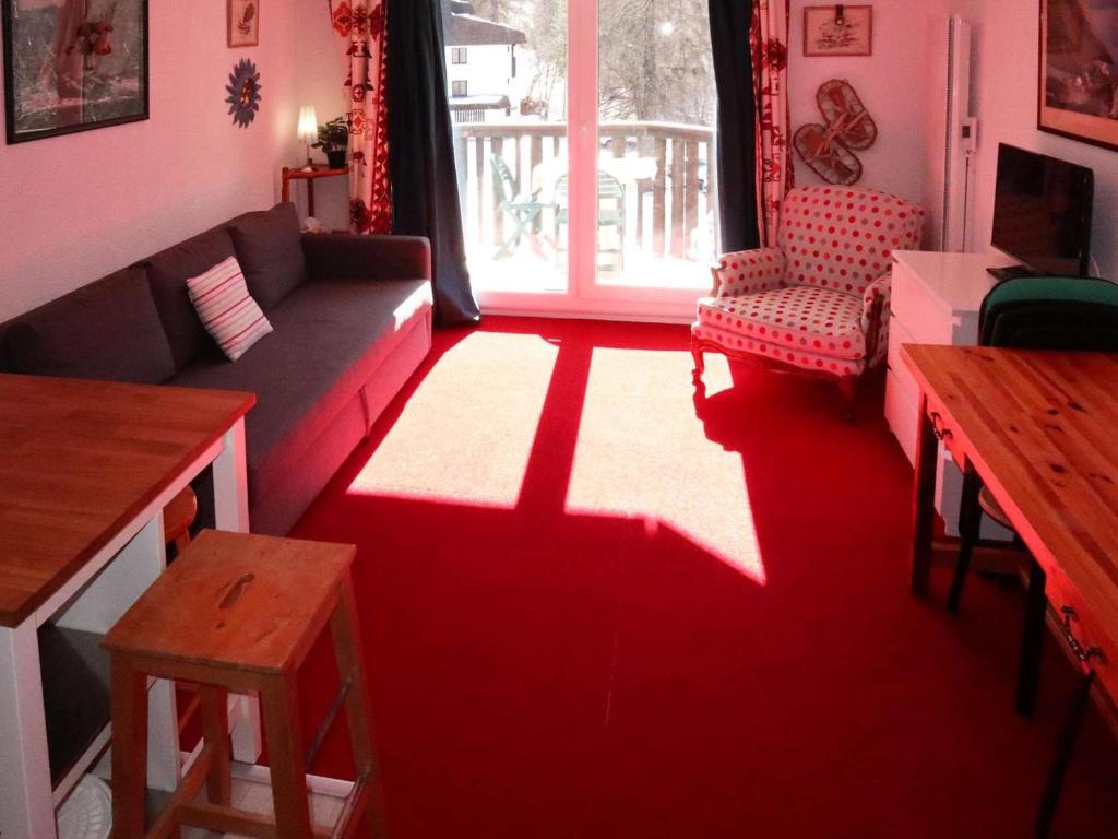- un salon avec un canapé et un tapis rouge dans l'établissement Studio spacieux pour 4 pers avec balcon et box à skis - FR-1-322-665, aux Orres