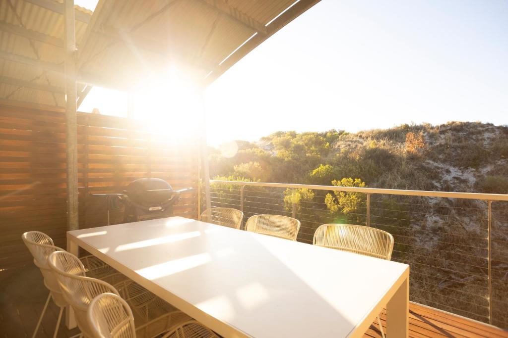 a white table and chairs on a balcony at Banksia Dunes Your Coastal Escape in Normanville in Normanville