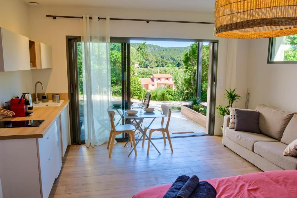 une cuisine et un salon avec une table et des chaises dans l'établissement Studio neuf et lumineux, à Cassis
