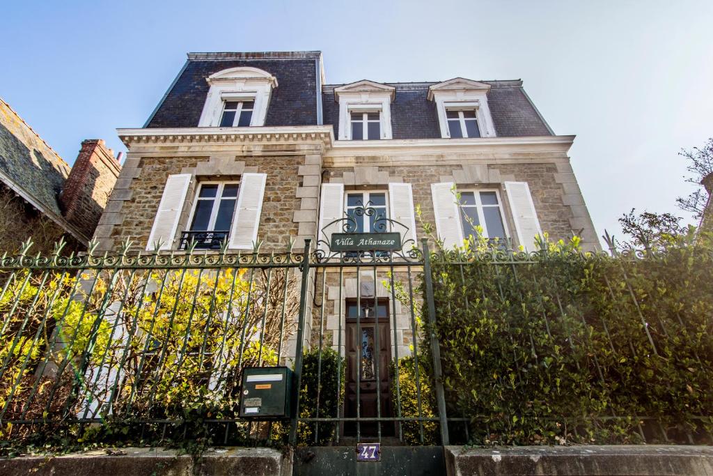 uma casa velha com uma cerca em frente em Villa Athanaze em Saint Malo