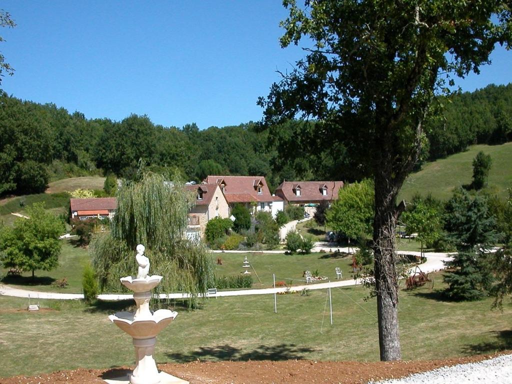 a park with a fountain in front of a house at Hameau les Combelles in Martel