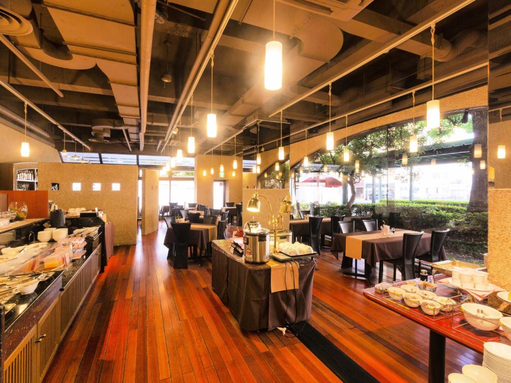 a dining room with tables and chairs in a restaurant at Ohta Grand Hotel in Ota