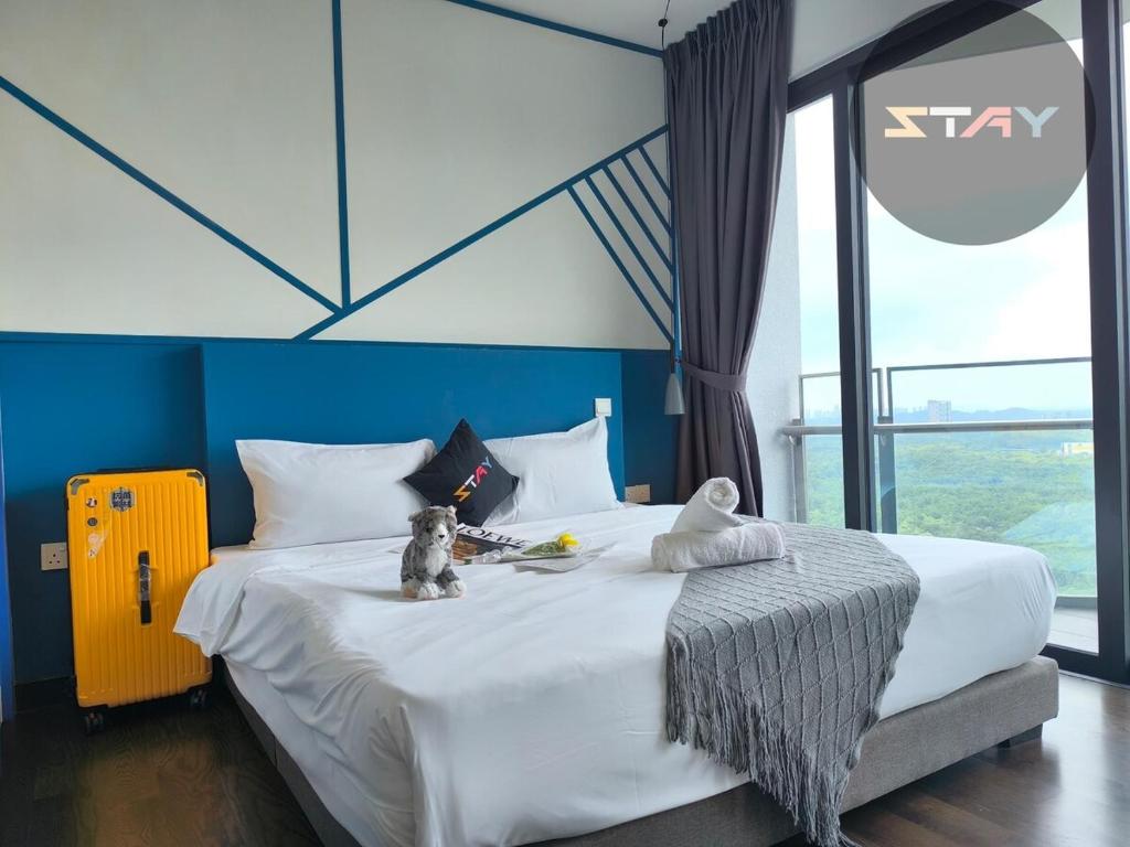 a large bed in a room with a large window at Almas Couple Stylish Urban Blue Netflix BySTAY in Iskandar Puteri