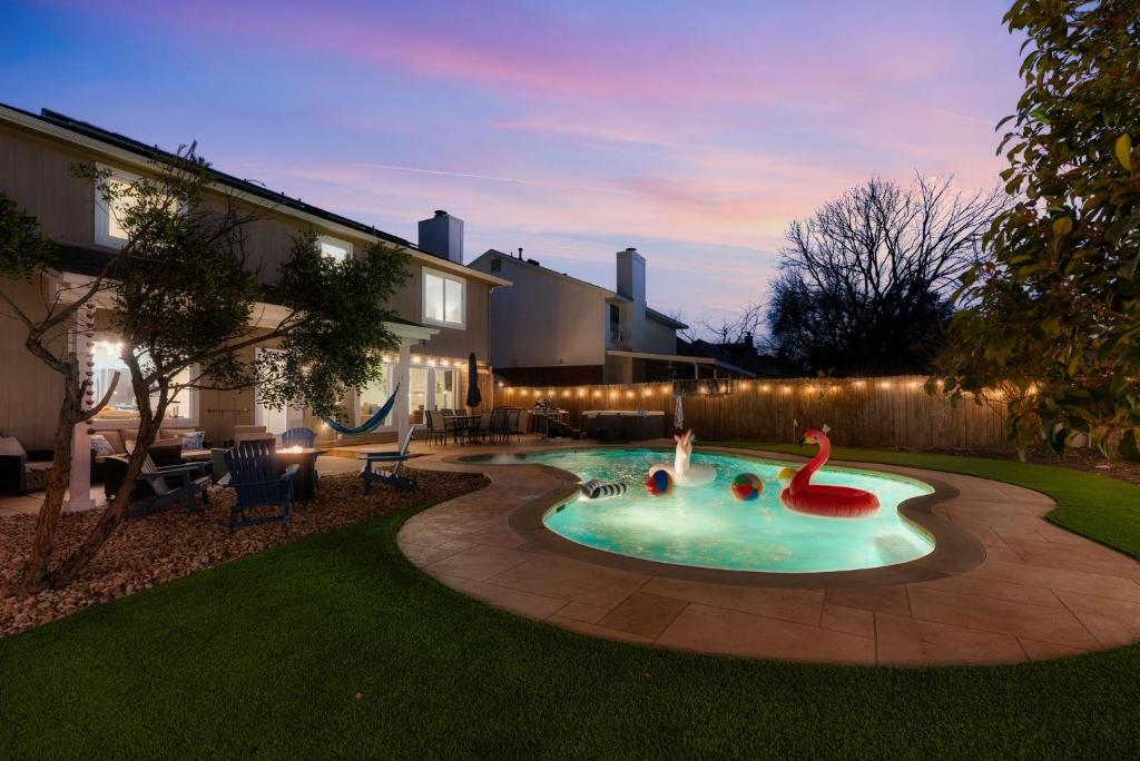 a backyard with a pool with a flamingo in it at Pool HotTub FirePit BBQ Billiard PS4 Golf in Pflugerville