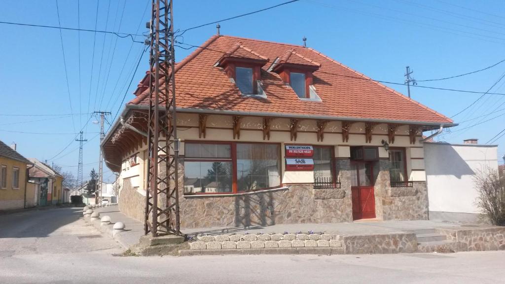 un pequeño edificio con techo rojo en una calle en Sasi Panzió 1, en Esztergom