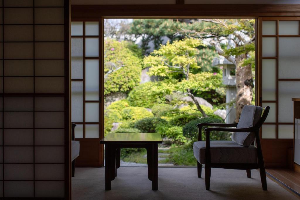une chaise et une table devant une fenêtre dans l'établissement Hagi No Yado Tomoe, à Hagi
