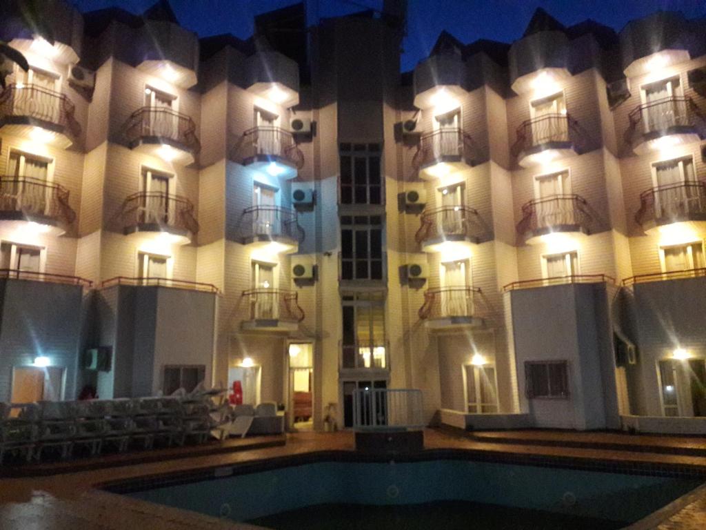 a hotel with a swimming pool in front of a building at Avlu 4 in Marmaris